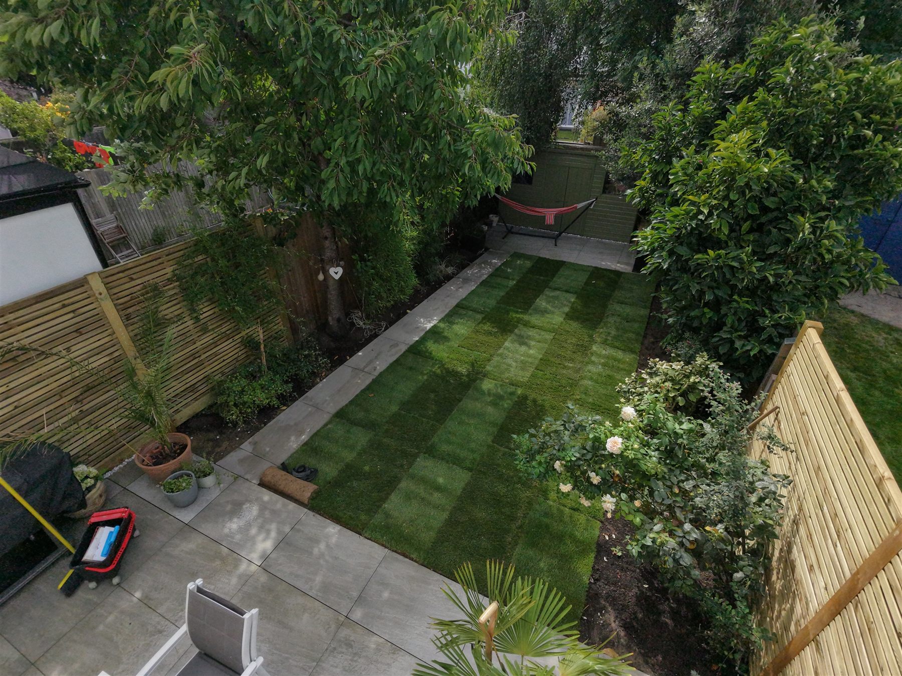 Aerial view of a landscaped garden with new turf, paving and planting borders, Surrey