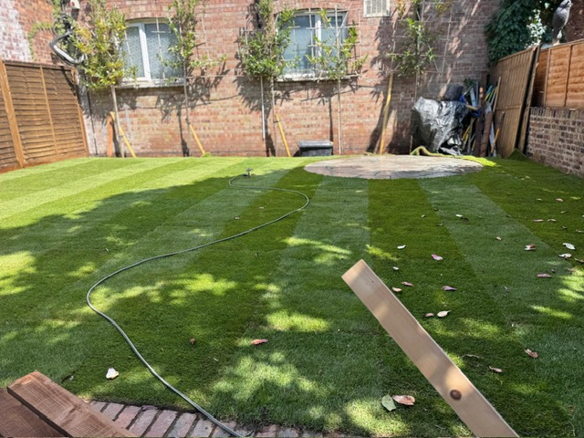 Freshly laid striped turf with circular paved feature, Surrey